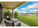 Relaxing covered patio with seating overlooking the lawn and pond at 13015 Homestead Ln, Parrish, FL 34219