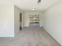 Bright living room with neutral carpet, paint and sliding doors leading to the backyard at 14315 Knoll Ridge Dr, Tampa, FL 33625