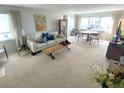 Inviting living room featuring neutral tones, large windows with bright natural light, and cozy seating area at 500 The Esplanade N # 405, Venice, FL 34285