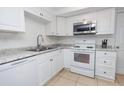Bright kitchen with stainless steel appliances, granite countertops, white cabinets and tile floors at 3818 Moog Rd, Holiday, FL 34691
