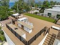 Rooftop deck with outdoor kitchen, dining, and lounging spaces with synthetic turf at 415 N Bay Blvd, Anna Maria, FL 34216