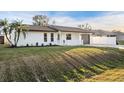 Well-manicured lawn and garden beds frame this charming single-story home with white picket fence and freshly painted exterior at 4107 Mulgrave Ave, North Port, FL 34287
