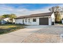 A single story home with an extra long driveway made of light brown pavers in a well manicured lawn at 4107 Mulgrave Ave, North Port, FL 34287
