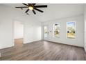 Bright living room with wood-look flooring, ceiling fan, and updated door and windows bringing in natural light at 4107 Mulgrave Ave, North Port, FL 34287