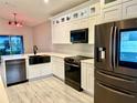 Modern kitchen featuring stainless steel appliances, white cabinets and stone countertops at 8283 47Th Street E Cir, Palmetto, FL 34221
