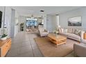 Bright living room with tile floors, tan furnishings, and an open dining area bathed in natural light at 507 Circlewood Dr # O2, Venice, FL 34293