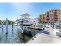 Dock featuring a boat lift and the building in the background, providing convenient and secure boat storage at 606 Riviera Dunes Way # 604, Palmetto, FL 34221