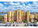 Stunning multi-story building with a lushly landscaped entrance and ample parking on a beautiful sunny day at 606 Riviera Dunes Way # 604, Palmetto, FL 34221