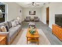 Bright living room featuring a comfortable gray sofa, modern ceiling fan, and stylish decor at 2117 W Paris St, Tampa, FL 33604