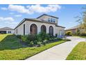 View of the front and side of the home highlighting the landscaped yard and three-car garage at 12887 Tortoise Shell Pl, Riverview, FL 33579