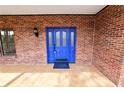 Close-up of the inviting blue front door with glass panels, set in a brick facade at 6604 Stafford Terrace Ave, Plant City, FL 33565