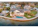 Waterfront home featuring a private pool, patio, and manicured lawn at 1903 Gulfview Dr, Holiday, FL 34691