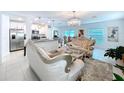 Open-concept living room with kitchen view featuring stylish furnishings and ample natural light at 6744 Back Forty Loop, Zephyrhills, FL 33541
