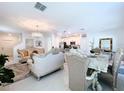 Bright and airy living room featuring elegant furnishings and a modern chandelier at 6744 Back Forty Loop, Zephyrhills, FL 33541