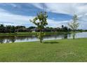 Scenic backyard featuring a tranquil lake view and lush green grass at 7037 Towering Spruce Dr, Riverview, FL 33578