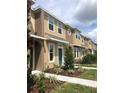 Modern townhome exterior with neutral tones, blue door and well-maintained landscaping at 7037 Towering Spruce Dr, Riverview, FL 33578
