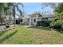 Stunning home featuring a lush green lawn and a well-maintained exterior, complete with an attached garage at 4721 Country Manor Dr, Sarasota, FL 34233