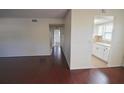 Open-concept layout with wood floors, neutral walls, and view into adjacent kitchen area at 6026 22Nd N Ave # 4, St Petersburg, FL 33710