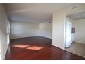 Bright living room with wood floors leading to the kitchen with a white refrigerator at 6026 22Nd N Ave # 4, St Petersburg, FL 33710