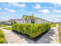 Side view of a well-maintained single-Gathering home with trimmed shrubs and healthy green lawn at 16397 Preservation Blvd, Punta Gorda, FL 33982