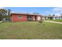 Cozy single-story home with a spacious front yard, blue outdoor chairs and green lawn at 1768 Suffolk Dr, Clearwater, FL 33756