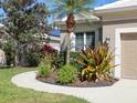 Home's front yard has lush plants, decorative mulch, and a sidewalk at 5011 88Th E St, Bradenton, FL 34211