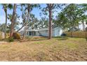 Spacious backyard with mature trees, partial fence, and a view of the back of the home at 530 Foxglove Rd, Venice, FL 34293