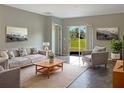 Bright living room with a sliding glass door and gray accent furniture surrounding a light-colored rug at 14853 Crescent Rock Dr, Wimauma, FL 33598
