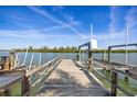 Exterior shot of weathered wooden dock with boat lift, offering picturesque waterfront views on a bright, sunny day at 318 182Nd E Ave, Redington Shores, FL 33708