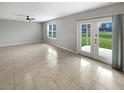 Spacious living room with tile floors, a ceiling fan, and sliding doors to the outside at 36880 Precita Ter, Zephyrhills, FL 33542