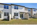 White two-story home featuring a small backyard with sliding glass doors for outdoor access and a privacy fence at 11826 Sylvia St, Dade City, FL 33525