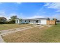 The exterior of a light blue house, with fresh landscaping, a well-manicured lawn, and a long driveway at 511 Sharon Cir, Port Charlotte, FL 33952