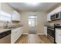 Open kitchen featuring stainless appliances, wood-look floors, and granite countertops at 2634 E 38Th Ave, Tampa, FL 33610