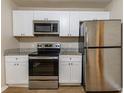 Bright kitchen featuring stainless steel appliances, granite counters, and white cabinets at 2634 E 38Th Ave, Tampa, FL 33610
