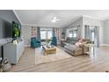 Spacious living room featuring wood floors, neutral decor, and abundant natural light from sliding glass doors at 6731 Ranger Dr, Tampa, FL 33615