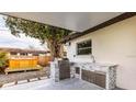 Outdoor kitchen features a built-in grill, sink, stone accents, and a spa or hot tub at 1714 Bayou Grande Ne Blvd, St Petersburg, FL 33703