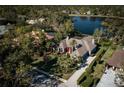 Expansive waterfront property showcasing a well-manicured lawn, mature trees, and circular driveway at 7705 Weeping Willow Cir, Sarasota, FL 34241