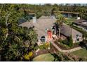 Charming waterfront home with meticulously manicured grounds, elegant front door, and lush trees at 7705 Weeping Willow Cir, Sarasota, FL 34241