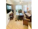 Living room with tile floors, rattan furniture, palm tree rug, and white walls at 19417 Gulf Blvd # B209, Indian Rocks Beach, FL 33785