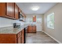 Well-lit kitchen features wood cabinets, granite countertops, stainless steel appliances, and wood flooring at 3408 Phillips St, Tampa, FL 33619