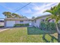 Inviting single story home with a well-maintained lawn, mature plants, and an attached garage at 12339 138Th N St, Largo, FL 33774