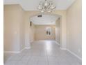 Open-concept living area with tile flooring, arched doorways, and neutral paint throughout at 15107 Searobbin Dr, Lakewood Ranch, FL 34202