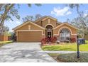Beautiful single-story home with lush landscaping, brick accents, a two-car garage, and an inviting entrance at 2727 Brookville Dr, Valrico, FL 33596