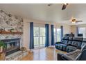 Cozy living room features a stone fireplace, hardwood floors, and sliding doors to the balcony at 373 Hile Ln, Punta Gorda, FL 33982