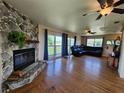 Spacious living room with a stone fireplace, hardwood floors, and plenty of natural light at 373 Hile Ln, Punta Gorda, FL 33982