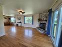 Bright living room featuring hardwood floors, stone fireplace, and access to the outdoor deck at 373 Hile Ln, Punta Gorda, FL 33982