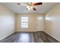 Living room features modern gray vinyl flooring, neutral paint, a front window, and a ceiling fan with lighting at 8528 Gold Ridge Cir, Tampa, FL 33619