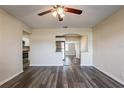 View of the living room with an opening to the kitchen and adjacent hallway; gray vinyl flooring and neutral paint at 8528 Gold Ridge Cir, Tampa, FL 33619