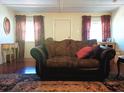 Cozy living room featuring hardwood floors, a comfortable sofa, and natural light from the windows at 4030 Worcester Rd, Sarasota, FL 34231