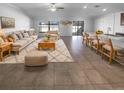 Bright, open-plan living room featuring neutral colors, tile floors, modern furnishings, and outdoor views at 36017 Stable Wilk Ave, Zephyrhills, FL 33541